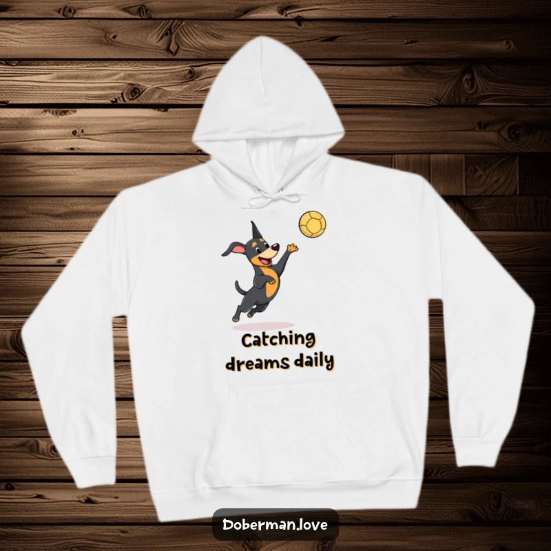 Funny kawaii Doberman hoodie featuring a playful dog leaping to catch a ball, embodying speed and adorable humor.