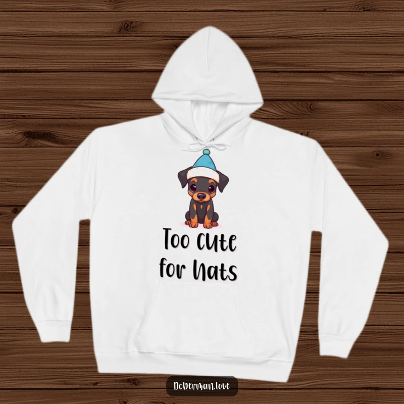 Funny hoodie featuring a Doberman puppy looking bewildered while attempting to wear an comically small hat.