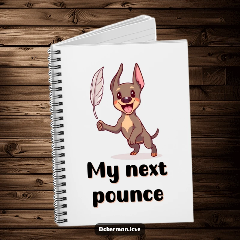 Funny Kawaii Doberman notebook with an energetic dog pouncing at a feather, ideal for capturing ideas and doodles.