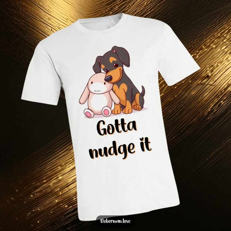 Funny Doberman playfully nudging a large soft toy, captured on a comfortable t-shirt, perfect for dog enthusiasts.