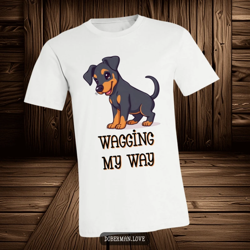 Funny Doberman puppy t-shirt featuring a cute puppy with floppy ears and an energetically wagging tail.