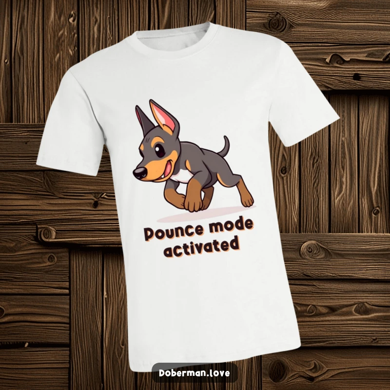 Funny Doberman puppy t-shirt depicting an energetic puppy captured mid-pounce with intense focus, showcasing determination and playful power.
