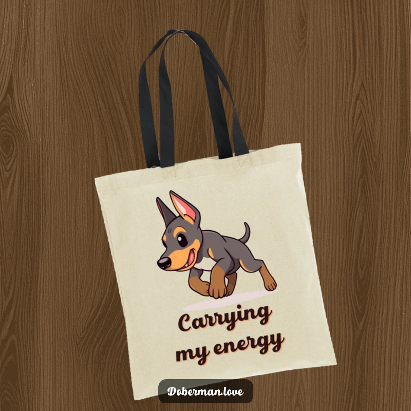 Funny Doberman puppy tote bag showing an energetic puppy in mid-pounce with determination, ready to carry your items with playful power.