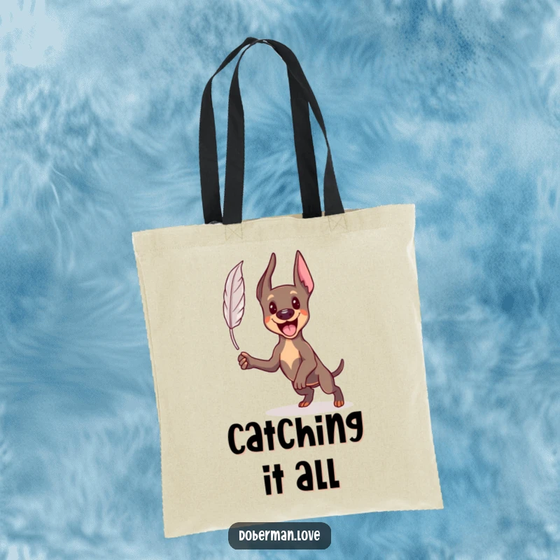 Funny Kawaii Doberman tote bag showcasing an energetic dog mid-pounce, chasing a floating feather, practical and amusing.