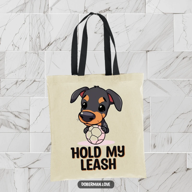Funny Kawaii Doberman Tote Bag showing a dog balancing a small ball on its snout, for humorous carrying.